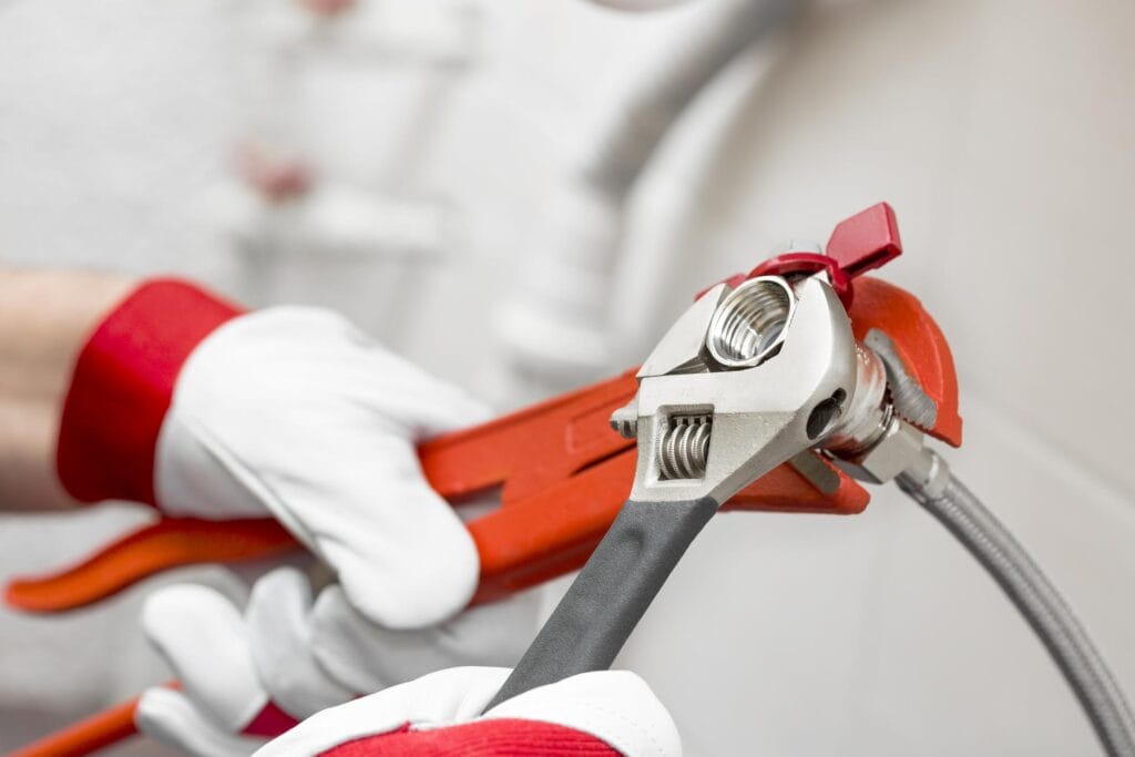 Plumber holding pipe wrenches for an emergency repair in Fort Pierce