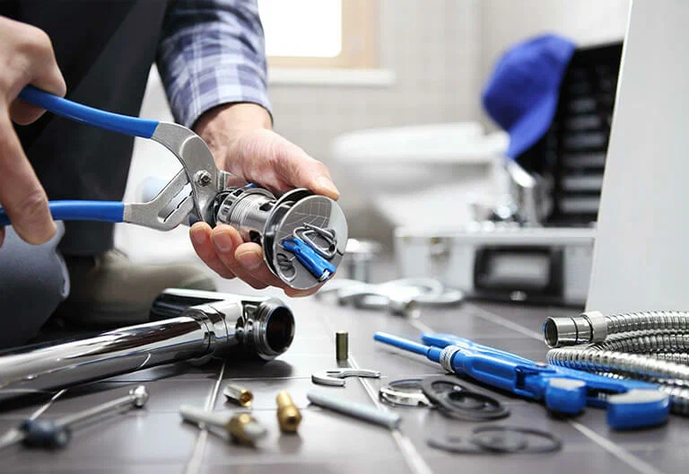 Technician repairing a plumbing fixture with professional tools in Fort Pierce