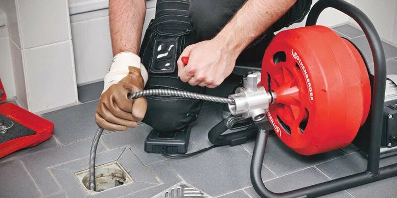 Plumber using a drain-cleaning machine in Fort Pierce