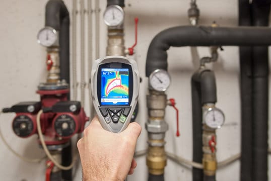 Plumber using a thermal imaging camera to inspect pipes in Fort Pierce