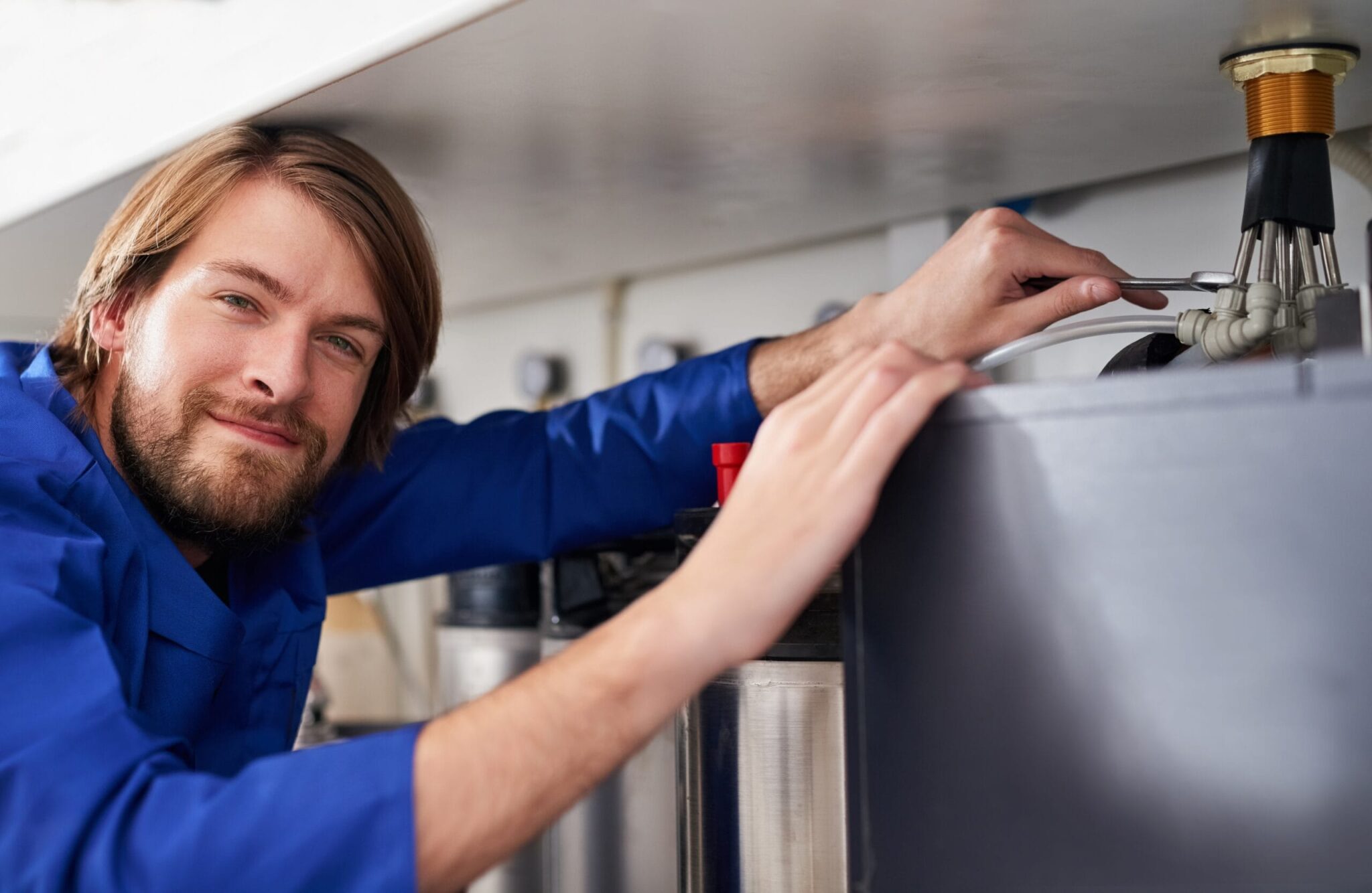 Technician servicing a residential water heater tank in Fort Pierce