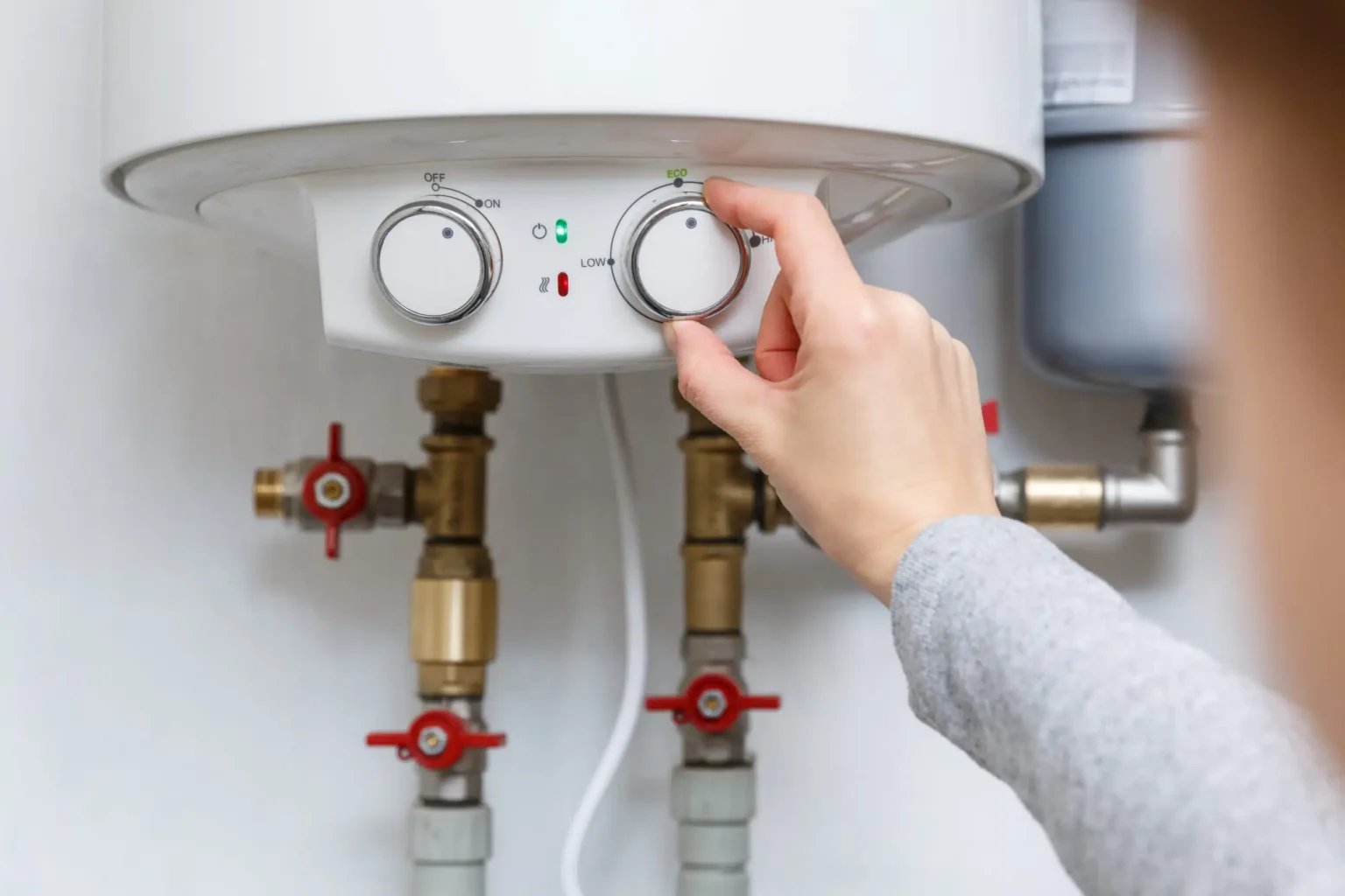 Homeowner adjusting the temperature controls on a water heater in Fort Pierce